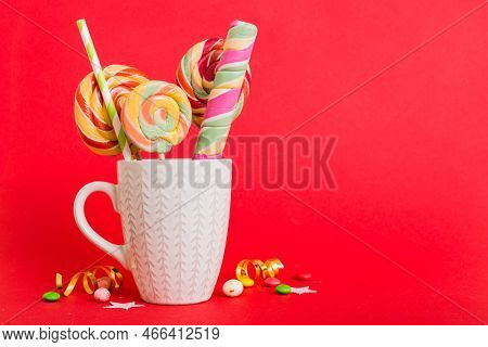 Colorful Candies In Cup On Table On Light Background Background. Large Swirled Lollipops. Creative C