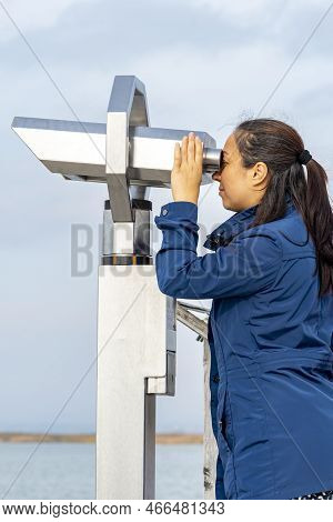 A Female Tourist Looks Through A Binoscope On The Observation Deck. Concept: Viewing Stationary Bino