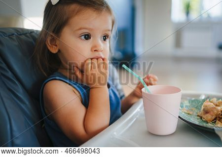 Baby Girl Eating Food With Hands On High Chair, Self-feeding, Enjoying With Healthy Nutrition. First