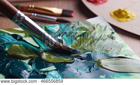 Brush On Artist's Canvas With Mixed Paints, Closeup