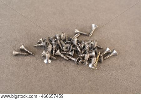 Self Drilling Screws For Roofing With A Drill And With Sealing Washer On Gray Background. Fasteners.