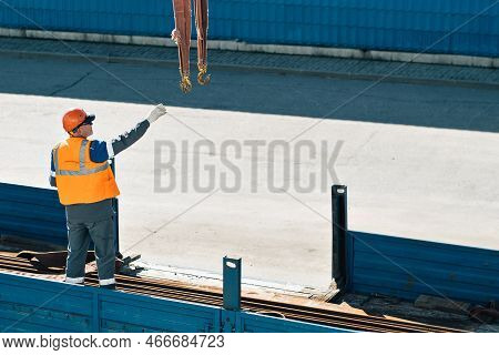 Slinger In Helmet And Vest Unloads Metal Pipes And Fittings From Truck Body On Clear Day.. Productio