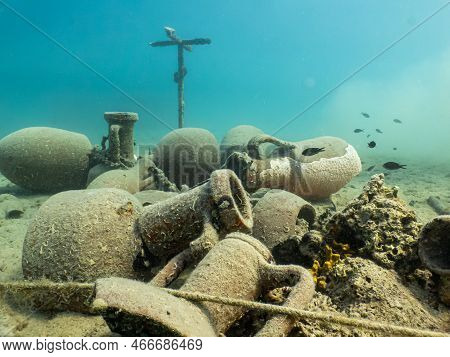 Antique Amphoras On A Sandy Sea Floor. Beautiful Turquoise Water In The Background