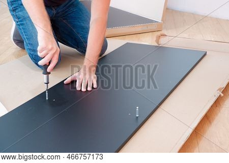 Assembling Furniture. Furniture Assembly Worker Assembles Shelf. Worker Assembling Furniture. Contra