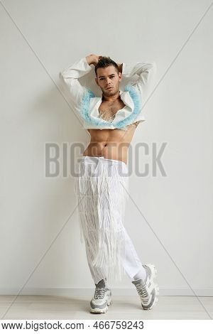 Vertical Full Length Portrait Of Non Binary Man Wearing Crop Top Posing Against White In Fashion Stu