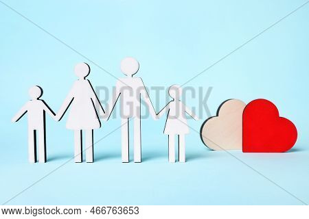 Figures Of Family Stainding Near Heart On Light Blue Background. Insurance Concept
