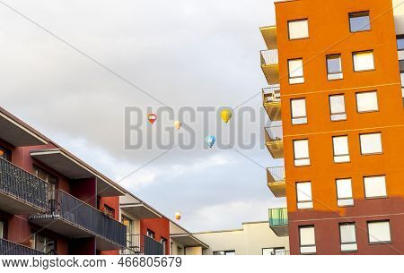 Balloons Flying In City Against Sky. Many Hot Air Balloons Of Different Shapes And Colors. Front Vie