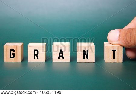 Wooden Cube With The Word Grant. Business And Grant Concept. The Concept Of Giving