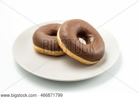 Tasty Donuts Dessert With Chocolate Glossy Glaze In A Plate, Isolated On White Background. One Round