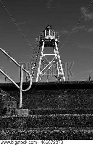 A View Along The Coastal Promenade Towards The Old Lighthouse On The Shoreline At Silloth In Cumbria