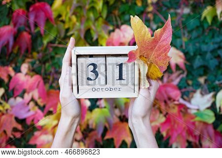 Wooden Calendar In The Hands Of A Young Woman, The Date Is October 31, Against The Background Of Aut
