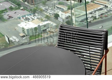 Coffee Table And Chair Against Picturesque Landscape Of City In Cafe, Closeup