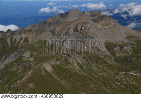 Close-up View Of The Landscape With Mountain Peak In The Foreground Against A Blue Sky With Clouds O