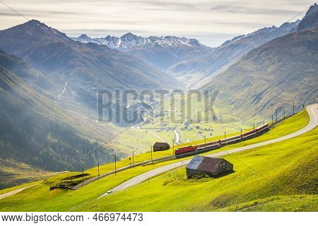 Swiss Train In The Alps Mountains Around Andermatt Urseren Valley, Uri, Switzerland