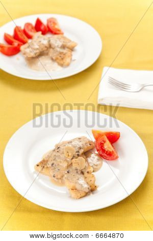 Seehecht Filets mit Käsesauce und Pilzen isoliert