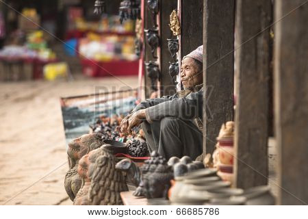 BHAKTAPUR, NEPAL - DEC 7, 2013: Unidentified Nepalese seller souvenirs. More 100 cultural groups have created an image Bhaktapur as Capital of Nepal Arts.