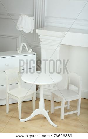 Interior white room with columns in ancient style and different furniture 