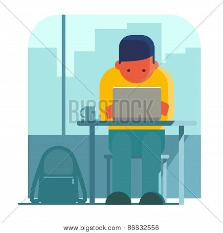 Young man working on laptop in cafe.