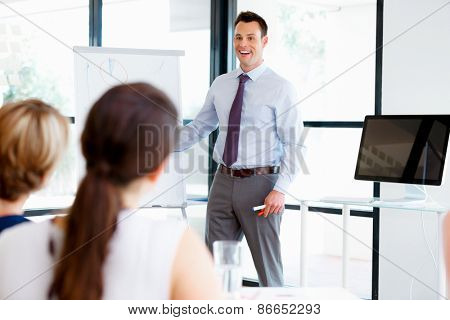 Businessman doing a presentaion in front of his collegues