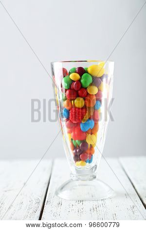 Colorful Candies In Glass On White Wooden Background