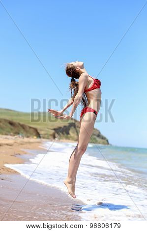 Successful happy girl jumping on the beach