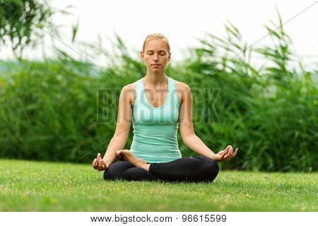 Woman Meditating In Pose Of Lotus