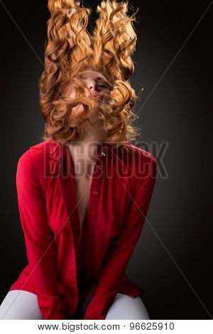 Sexy model posing waving her curly red hair