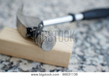 Close up of a hammer on a marble table.