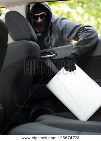Car theft - a laptop being stolen through the window of an unoccupied car.