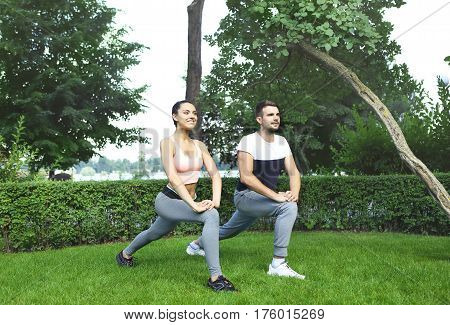 Young happpy couple exercising and stretching muscles before sport activity