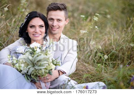 Young couple in love outdoor. Elegant bride and groom posing together outdoors on a wedding day. bride and groom in the Park. young couple in the woods. young couple in the grass. couple walking