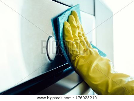 Man's Hand Cleaning The Kitchen Oven