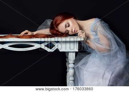 Sexy beautiful redhead girl with long hair. Perfect woman portrait on black background. Gorgeous hair and deep eyes. Natural beauty clean skin facial care and hair. Strong and thick hair. Wood table