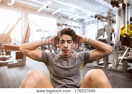 Fit hispanic man at abdominal crunch muscles exercises during training in fitness gym