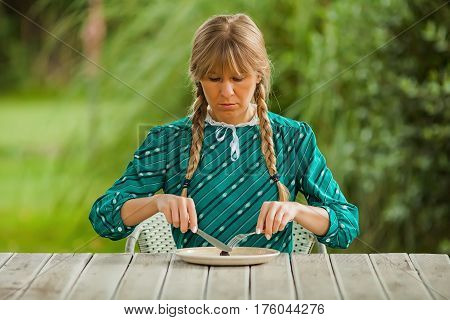 Young woman is having meager meal in times of scarcity.