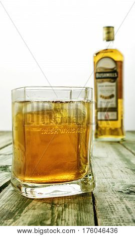 Editorial Photo Of Bushmills Whiskey Glass With Logo And  Blurred Bottle In Background