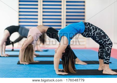 Group of women doing yoga - Upward bow or wheel posture