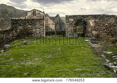 Entrance door and gate to the stone wall surrounding medieval monastery