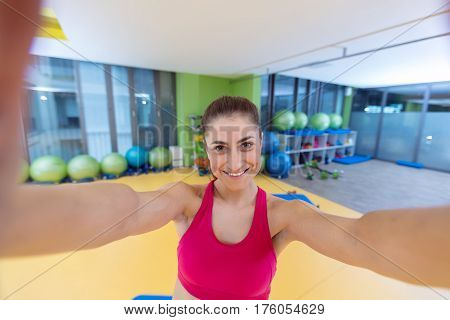 sport woman smile at camera self picture at gym, young girl picture herself exercising fitness center.