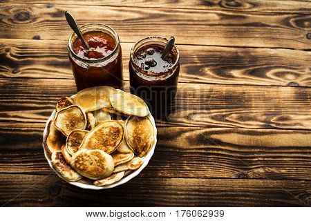 the homemade vegan pancackes with jam wooden background