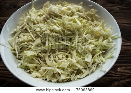 the chopped cabage in the bowl wooden background