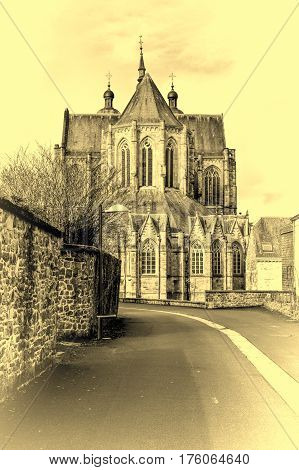 The street leading to the church in Belgium. Cathedral of St. Hubert in Belgium. Vintage Style Toned Picture