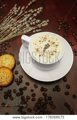 Cup of coffee with milk pussy-willow and dried branches and leaves at white background. Cake on desk