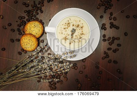 Cup of coffee with milk pussy-willow and dried branches and leaves at white background. Cake on desk