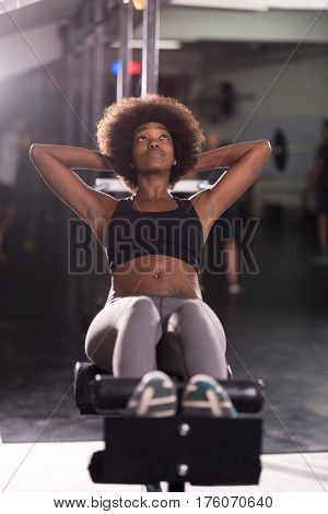 young fit african american woman doing sit ups in fitness studio at the gym.Abdominal exercises Sit up