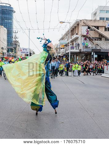 Participants At сarnival On Stilts Are Walking Along The Street