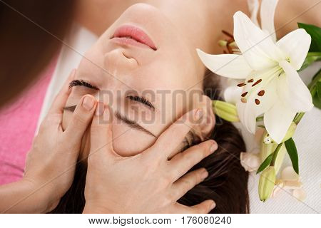 Facial beauty treatment at spa salon. Young woman relaxing while getting spa treatment. Beauty care