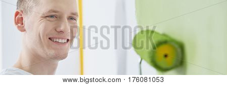 House painter with green paint roller panorama