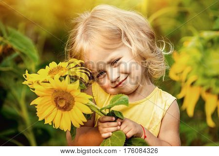 Happy little girl on the field of sunflowers in summer. beautiful little girl in sunflowers