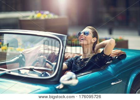 Portrait of beautiful sexy fashion woman model sitting in luxury retro cabriolet car